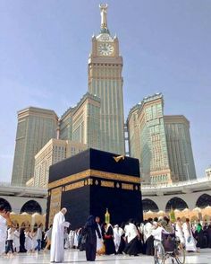 a group of people standing around a large black box in front of some tall buildings