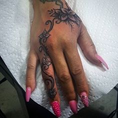 a woman's hand with pink and black designs on it