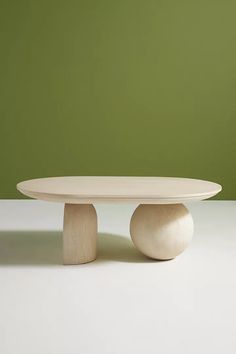 a white table with two wooden bases on it and a green wall in the background