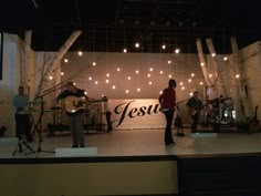 a group of people standing on top of a stage next to a sign that says jesus