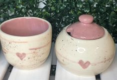 two ceramic pots with hearts painted on them