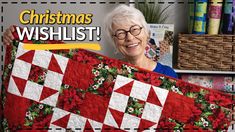 an older woman holding up a christmas wishlist quilt