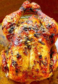 a close up of a cooked chicken in a pan with sauce on the bottom and sides