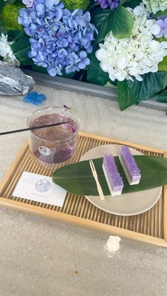 a tray with two pieces of cake on it next to a cup and some flowers