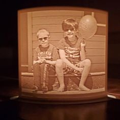 an old photo of two boys sitting on a bench with balloons in front of them