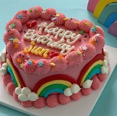 a birthday cake with the words happy birthday written on it and rainbows in frosting