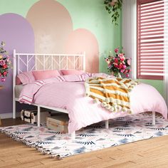 a bedroom decorated in pastel colors with flowers on the bed and rugs around it