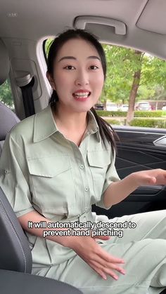 a woman sitting in the back seat of a car with her hand out to someone