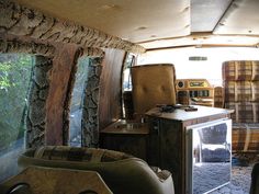 the interior of an old camper with wood trim and plaid bedspreads