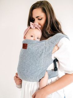 a woman holding a baby in a sling