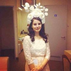 a woman in a white dress with flowers on her head