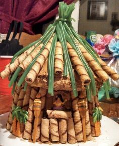 a cake made to look like a house with bamboo sticks sticking out of it's roof