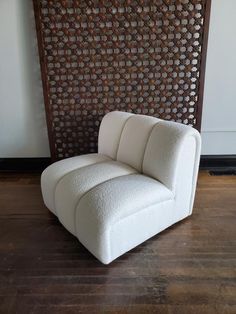 a white chair sitting on top of a hard wood floor next to a wooden wall