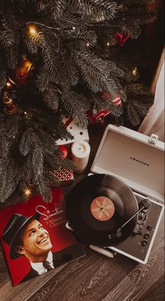 an old record player sitting next to a christmas tree