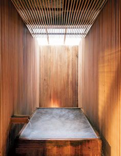 an indoor sauna with wooden slats on the walls and floor, in front of a window