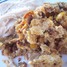 a close up of food on a plate with meat and bread crumbs next to it