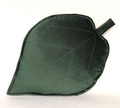 a green leaf shaped pillow on a white background