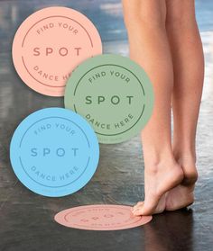 the feet of a woman standing on top of a black floor next to some colorful stickers