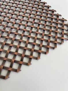 a close up view of a woven piece of cloth on a white surface with brown lines