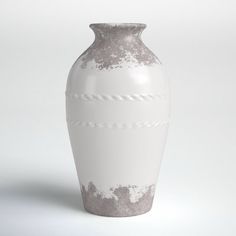 a white and gray vase sitting on top of a table