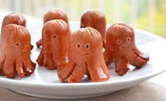 there are some little orange elephants on a white plate and one is made out of chocolate