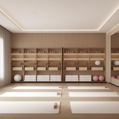 an empty room with yoga mats on the floor and shelves full of white objects in it