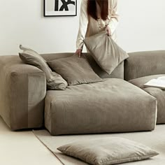 a woman standing on top of a large couch