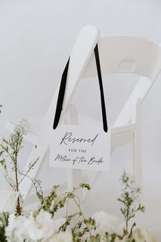 a white chair with a sign that says reserved for the mother of the bride