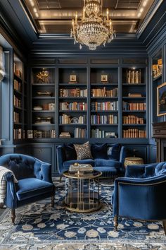 a living room filled with blue couches and bookshelves next to a chandelier