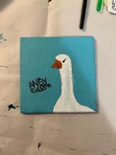 a painting of a white duck with an orange beak and the words angry goose painted on it