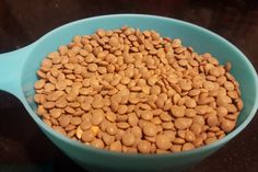 a blue bowl filled with peanuts on top of a black counter next to a brown table