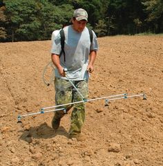 a man is walking in the dirt with a rope attached to his back while holding onto something