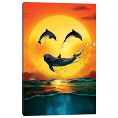 two dolphins jumping out of the water at sunset