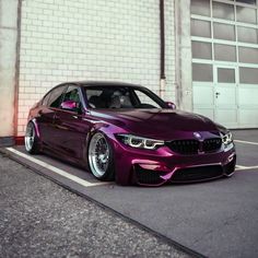 a purple car parked in front of a brick building