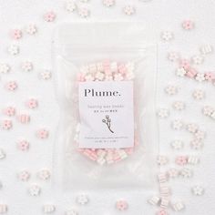 some pink and white flowers are in a plastic bag on a table with the words plumee written above it