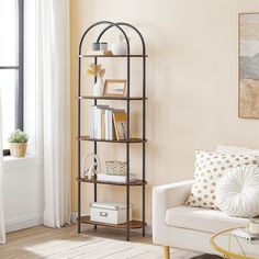 a living room filled with furniture and a book shelf next to a white couch in front of a window