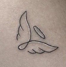 a small bird tattoo on the back of a woman's stomach, with wings