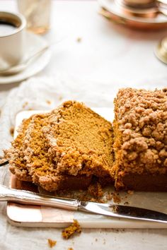 two pieces of cake sitting on top of a cutting board next to a knife and fork