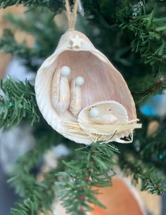 an ornament hanging from a christmas tree with two baby's feet in it