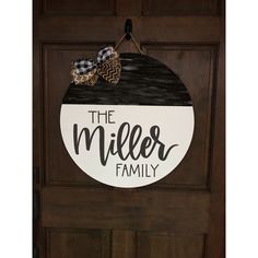 the miller family door hanger is hanging on a wooden door with a plaid bow