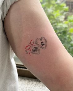 a person with a tattoo on their arm that has two hearts and a dog's paw