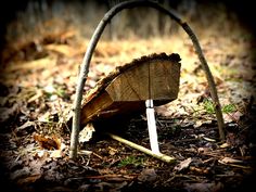 an old broken down tree stump in the woods with two wooden sticks sticking out of it