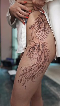 a woman's thigh with a bird tattoo on it