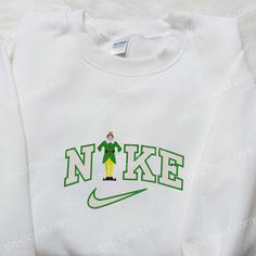 Introducing the Buddy Elf x Nike Embroidered Shirt, the perfect blend of style and holiday spirit. Made with premium quality materials, this shirt showcases the iconic Buddy Elf character, embroidered with precision and attention to detail. With its comfortable fit and vibrant colors, it’s the ideal attire for any Christmas gathering or movie night. As for our Christmas Movie Embroidered Hoodie, it’s a must-have for all film enthusiasts. Crafted with soft, cozy fabric, it features intricate embroidery of beloved Christmas movie characters, bringing a touch of nostalgia to your wardrobe. Stay warm and stylish throughout the holiday season with this Nike Cartoon, Disney Character Shirts, Nike Inspired, Custom Nikes, Inspirational Celebrities, Embroidered Sweatshirt, Embroidered Hoodie, Disney Halloween, Embroidered Tshirt