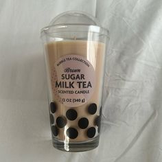 a glass cup filled with some kind of drink on top of a white table cloth