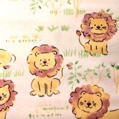 the fabric has lions on it and is yellow with green leaves around them, as well as pink flowers