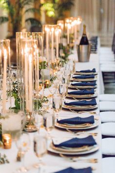 a long table is set with candles and place settings for an elegant dinner or party