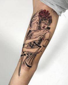 a woman is holding a knife and wearing a red hair tattoo on her arm,