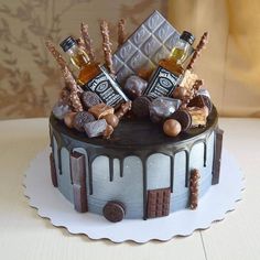 a chocolate cake with liquor bottles and candies on top