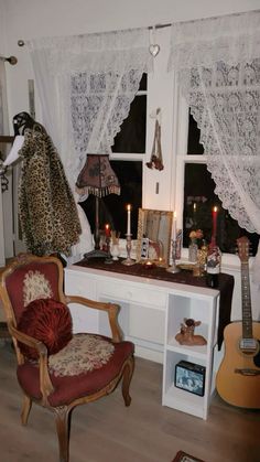 a room with a desk, chair and guitar in it